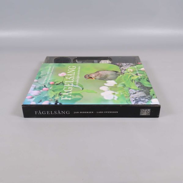 Fågelsång bok liggande, rygg synlig med titeln och författarnamn