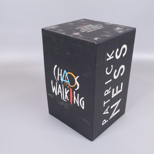 Svart box med Chaos Walking-loggan och Patrick Ness namn