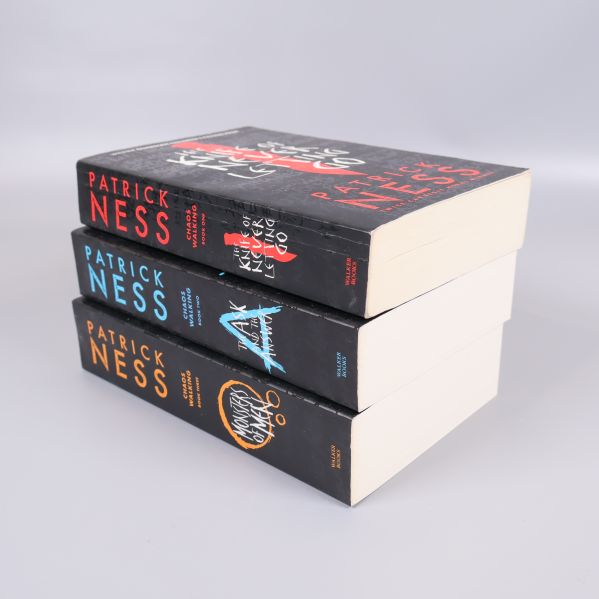 Trave med Chaos Walking-böcker som visar ryggarna