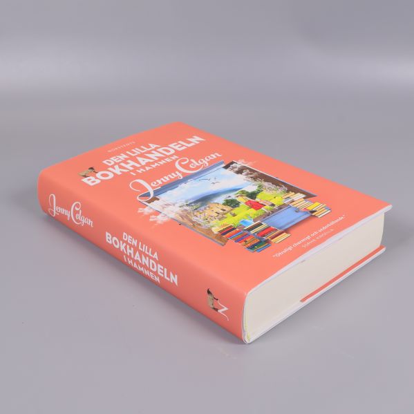 Boken Den lilla bokhandeln i hamnen i sned vinkel som visar ryggen