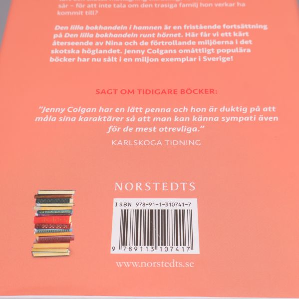 Närbild på baksidan visar ISBN och stapel med böcker