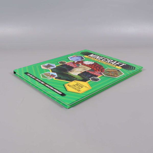 Minecraft boken fotograferad snett från sidan på grå bakgrund