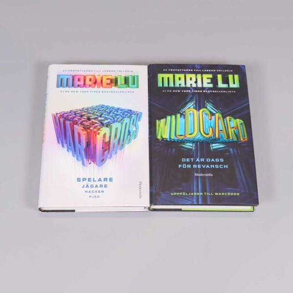 Två böcker, Warcross och Wildcard av Marie Lu, placerade sida vid sida med färgstarka omslag