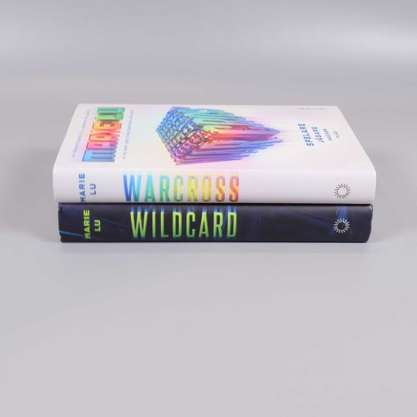 Ryggarna på Warcross och Wildcard staplade, färgglada och tydliga titlar