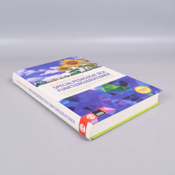 Boken Specialpedagogik och funktionsvariationer liggande, med synlig rygg och färgdetaljer