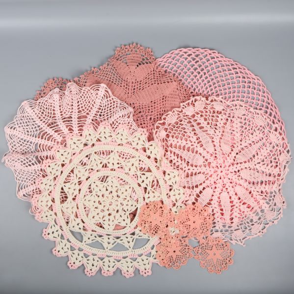 Rosa pastellfärgade virkade dukar spridda