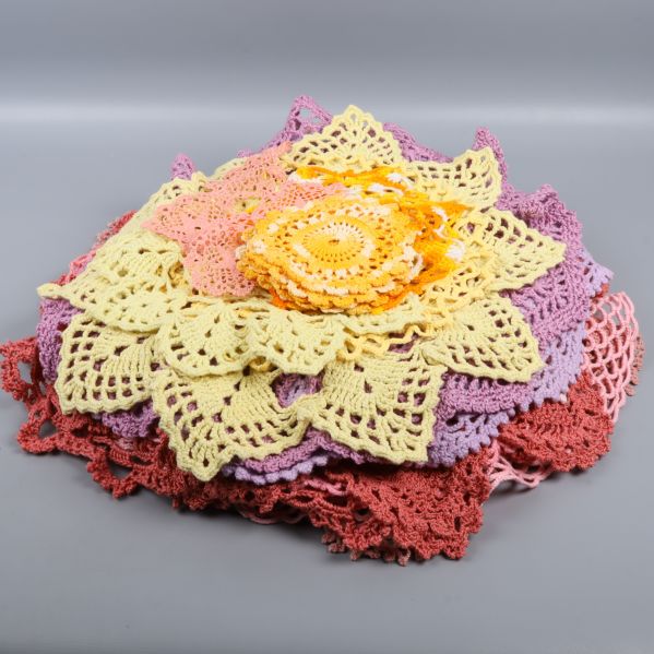 Färgglada virkade bordsdukar i en hög