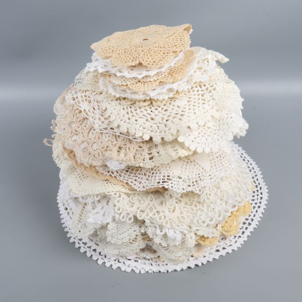 Hög med virkade dukar i beige och vitt