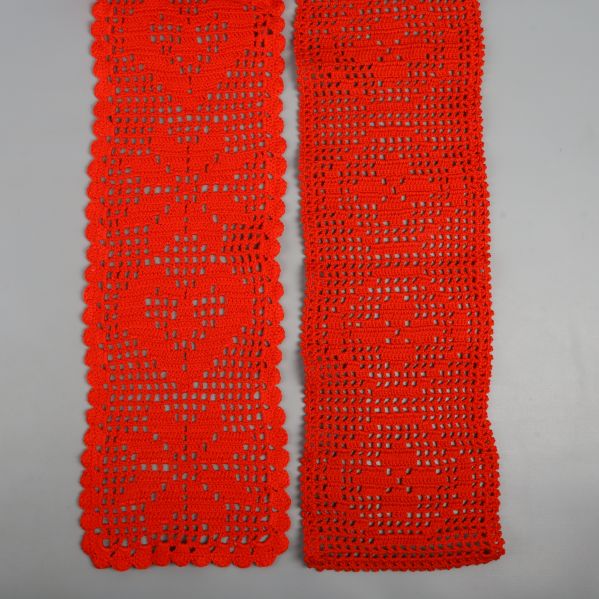 Två röda virkade dukar med hjärtmönster