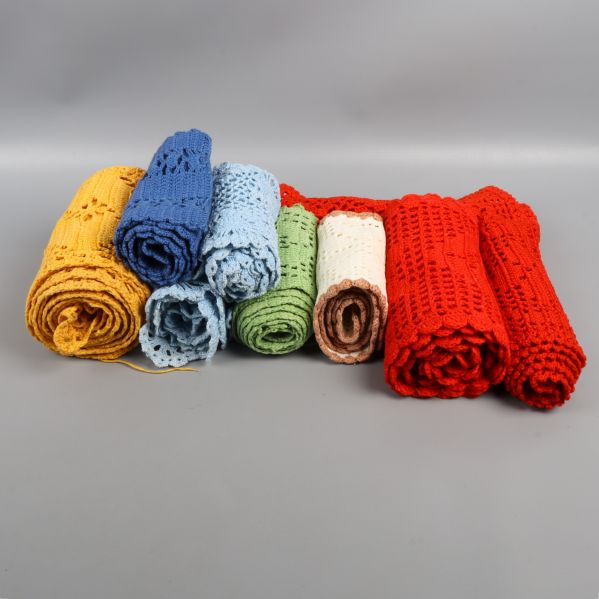 Olika färgglada virkade dukar rullade ihop