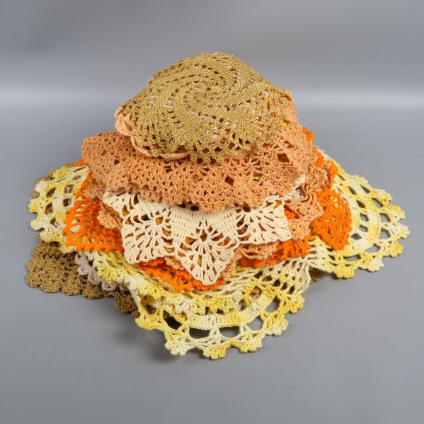 Stapel av virkade dukar i varierande nyanser