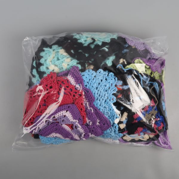 Flera virkade rutor i en plastpåse