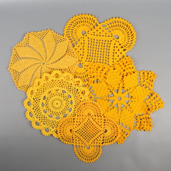 Flera gula virkade dukar i olika former