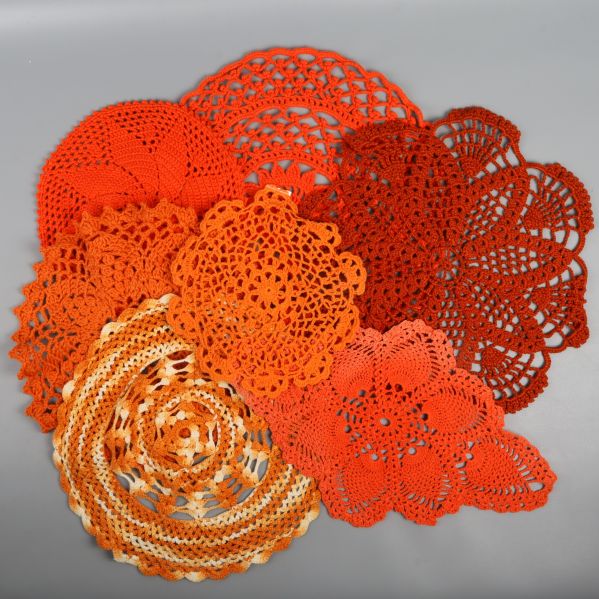 Flera orange virkade dukar i olika mönster