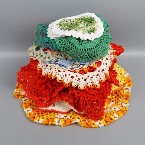 Hög med virkade dukar i olika färger