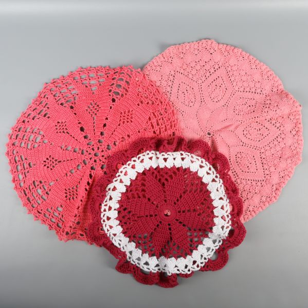 Tre olika virkade dukar i rött och rosa