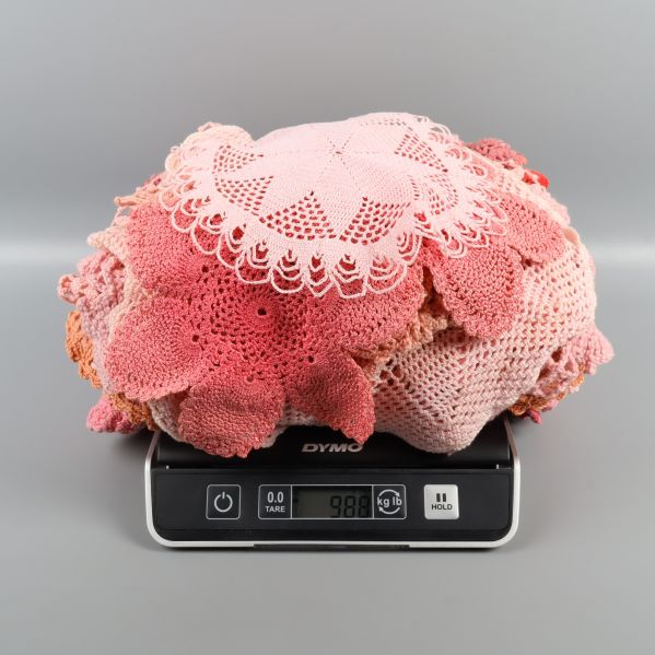 Hög med virkade dukar på våg som visar vikt