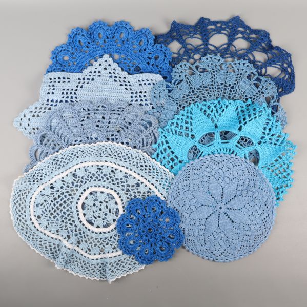 Samling av blå och vita virkade dukar