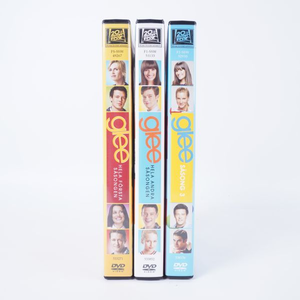 Ryggsidorna på tre Glee DVD-fodral syns bredvid varandra