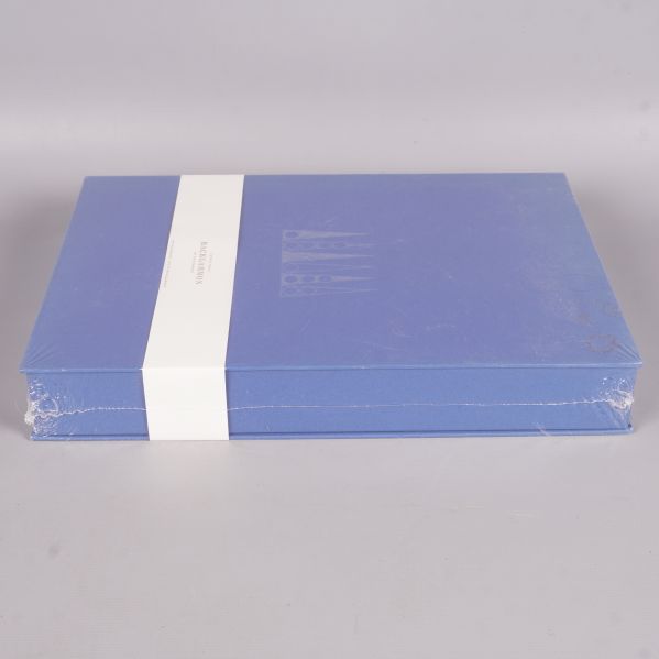 Backgammonspel box liggande i blått med vit banderoll