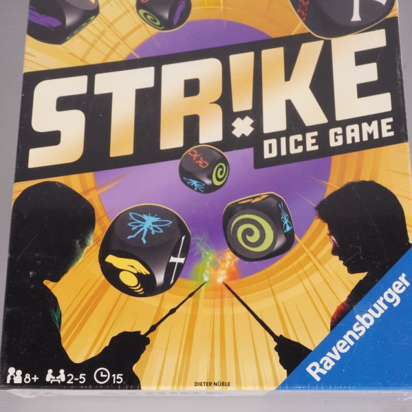 Närbild av spelbox med siluetter och magiska tärningar