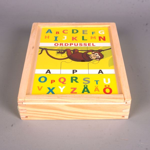 Ordpussel i trälåda från sidan med pusslets framsida synlig