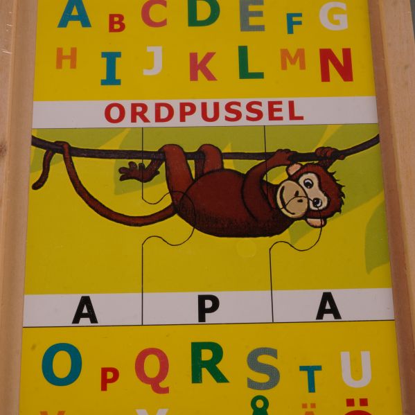 Närbild på pusslet med apa och bokstäver