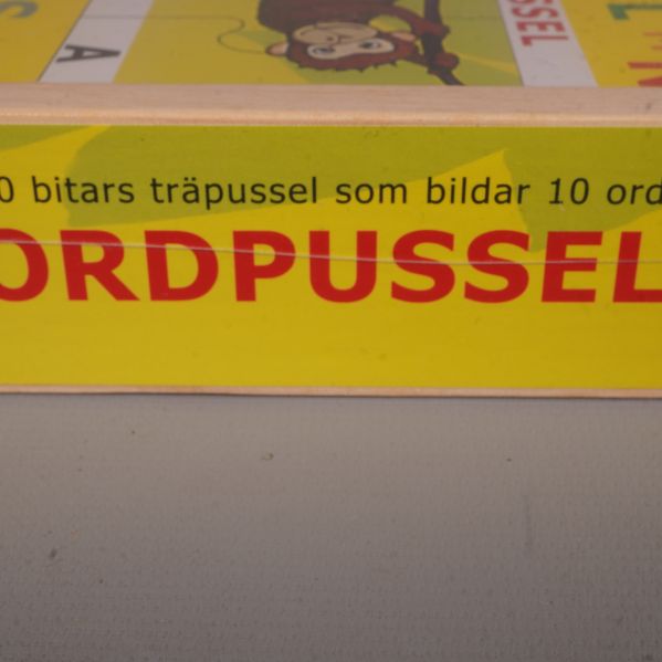 Närbild på sida av låda med texten ordpussel