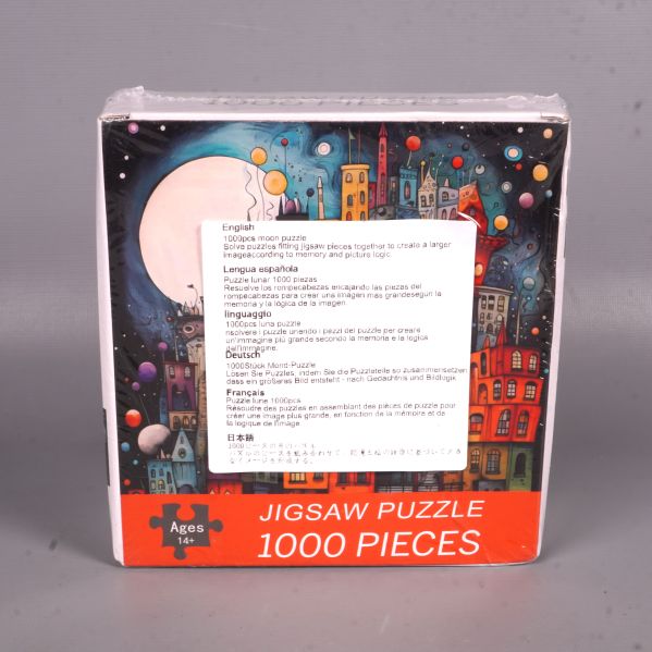 Pussellåda med färgglad stad och fullmån samt etikett på framsidan