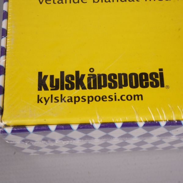 Närbild av Kylskåpspoesi logotyp på spelasken