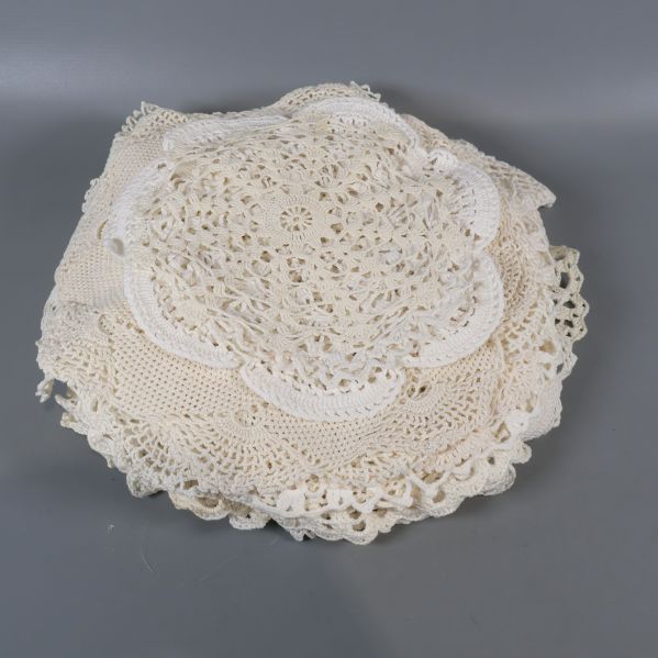 Hög med hopvikta ljusa virkade dukar