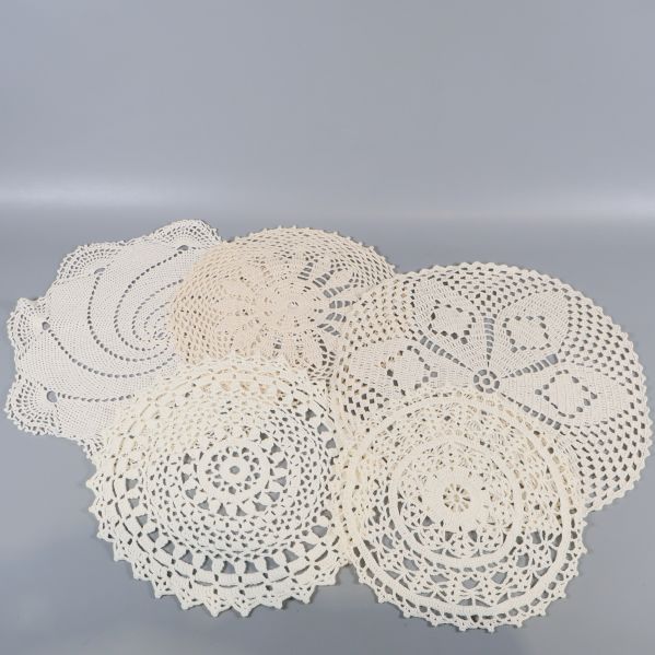 Tre virkade dukar i mjuka, runda mönster bredvid varandra