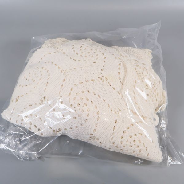 Plastpåse innehållandes ihopvikt virkad duk