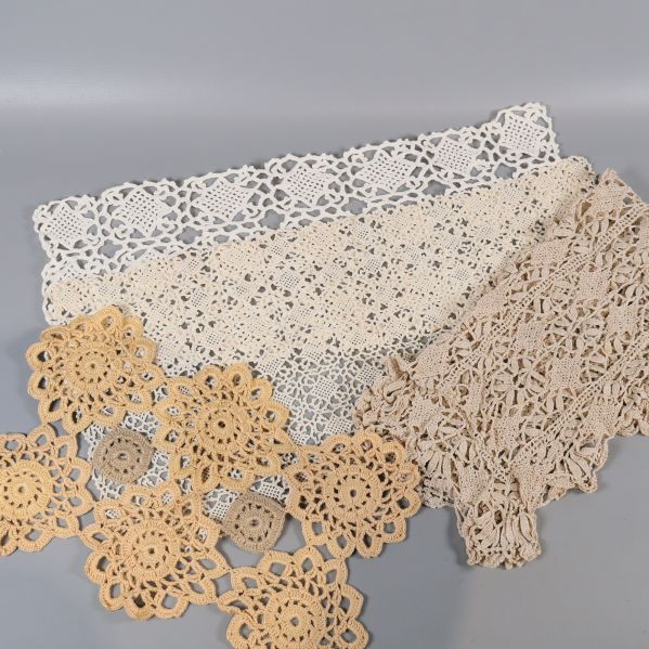 Detaljbild på flera olika virkade dukar i ljusa toner