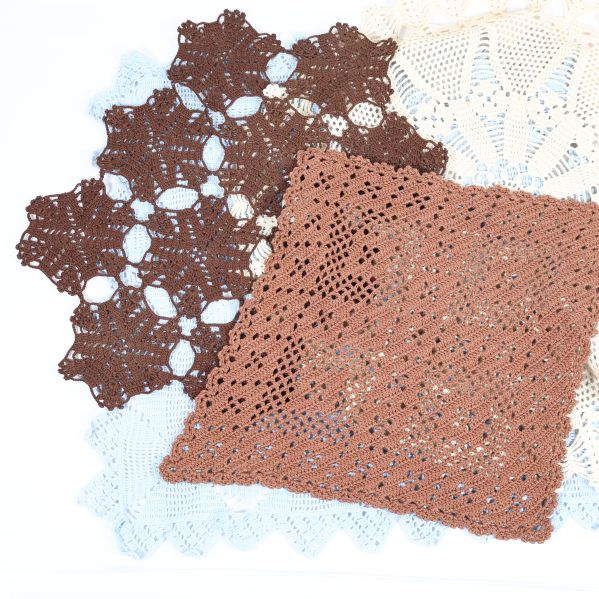 Närbild på bruna och ljusblå virkade dukar