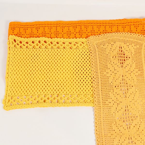 Närbild på två virkade dukar i gult och orange