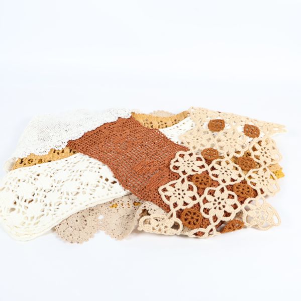 Utbredna virkade dukar i beige, vitt och ockragult