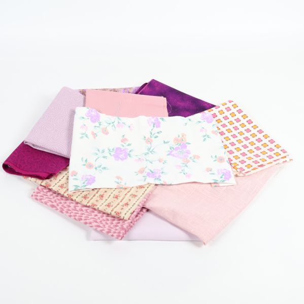 Textilpaket med vita, lila och pastellfärgade mönster