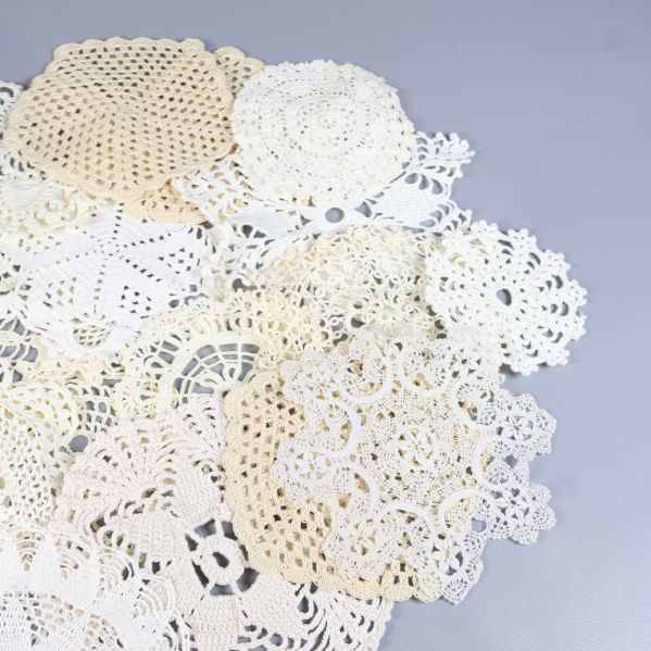 Samling av virkad spets i ljusa toner