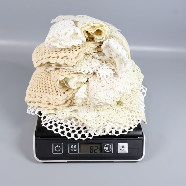Virkade spetsdukar på våg med vikt visad 840 gram