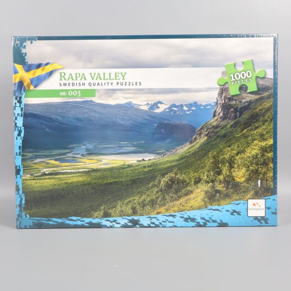 Framsidan av pusselask med landskap och svensk flagga