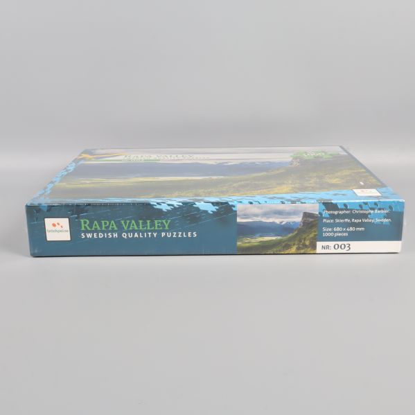 Sidan av pusselask med logotype, motiv och modellnummer