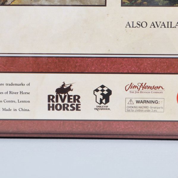 Närbild baksida av lådan med produktions- och varumärkeslogotyper