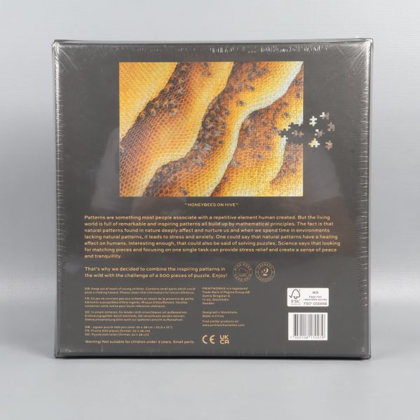 Baksidan av pussellåda med beskrivning och mönstrad bild