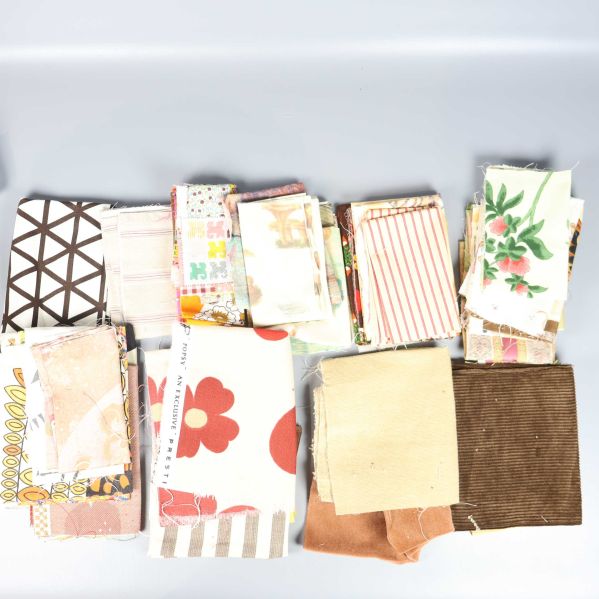 Färgglada tygbitar med olika mönster och storlekar uppdelade i högar