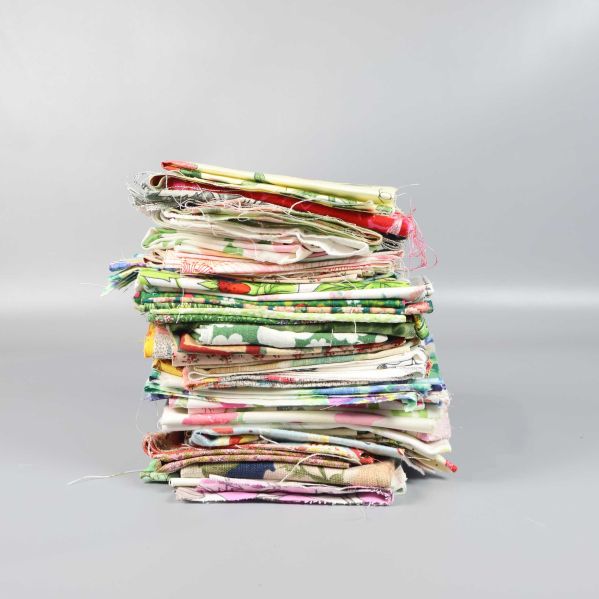 Staplad hög med tygbitar i olika mönster från sidan