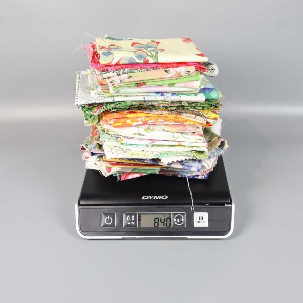 Tygbitar staplade på våg som visar vikten 840 gram