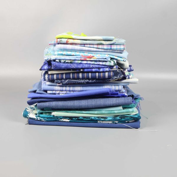 Staplade tygbitar med ränder och mönster i blå toner