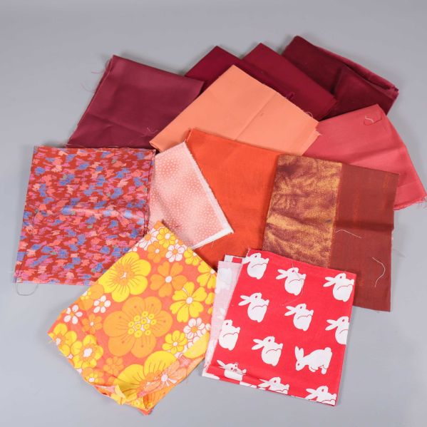 Samling tygbitar i röda, orange och gula nyanser