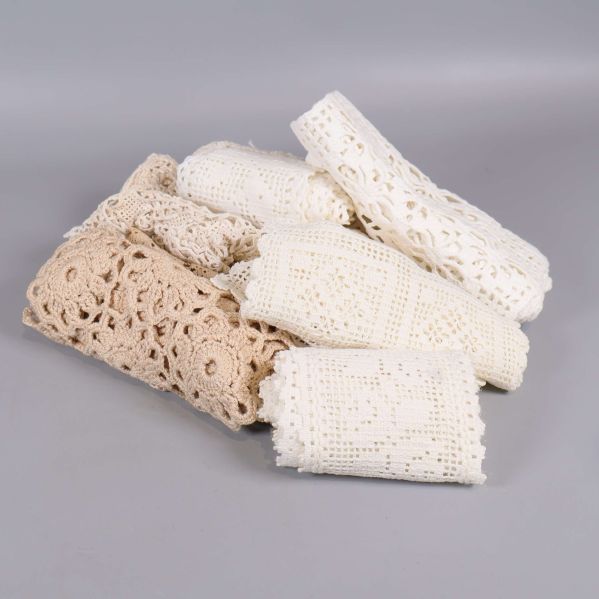 Flera vikta virkade spetsdukar i beige och gräddvitt